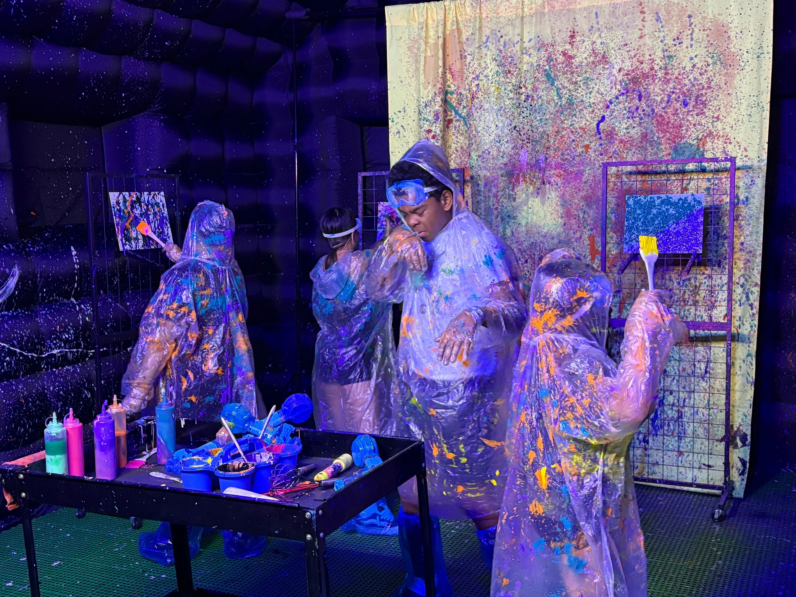 Guests enjoying colorful splatter painting at Paint Playground